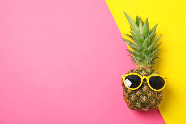 istock Pineapple with sunglasses on two tone background, space for text 1189927305