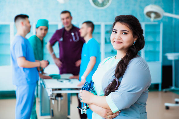 retrato de um doutor profissional bem sucedido. a equipe da faculdade de medicina. pessoas multinacionais - médico, enfermeiro e cirurgião. um grupo de graduados de uma universidade médica em uma sala cirúrgica. - medical student healthcare and medicine book education - fotografias e filmes do acervo