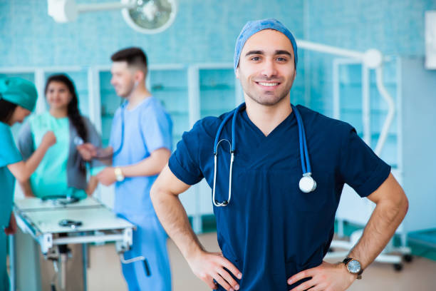 portrait d'un médecin professionnel réussi. le personnel de la faculté de médecine. multinationales - médecin, infirmière et chirurgien. un groupe de diplômés d'une université médicale dans une salle de chirurgie. - manual operation photos et images de collection