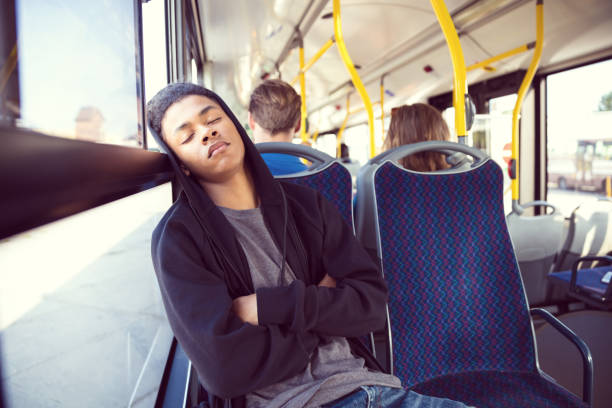 adolescente niño durmiendo mientras viaja en autobús - front view bus photography day fotografías e imágenes de stock