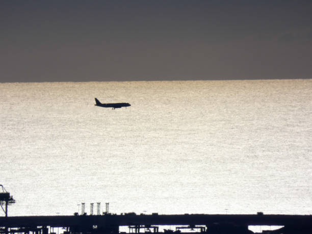 istock plane descending with the sea in the background 1189929466