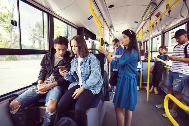 amici adolescenti che usano il cellulare in autobus - transportation bus mode of transport public transportation foto e immagini stock