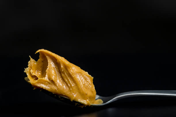 Peanut butter A spoonful of peanut butter on black background TEASPOON OF PEANUT BUTTER stock pictures, royalty-free photos & images