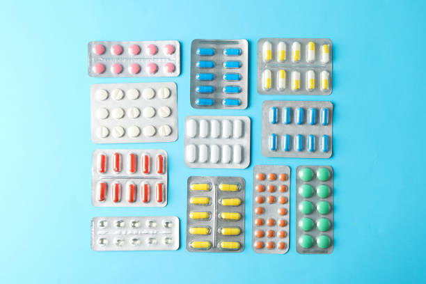 istock Flat lay with different pills in blister packs on blue background, top view 1189932326