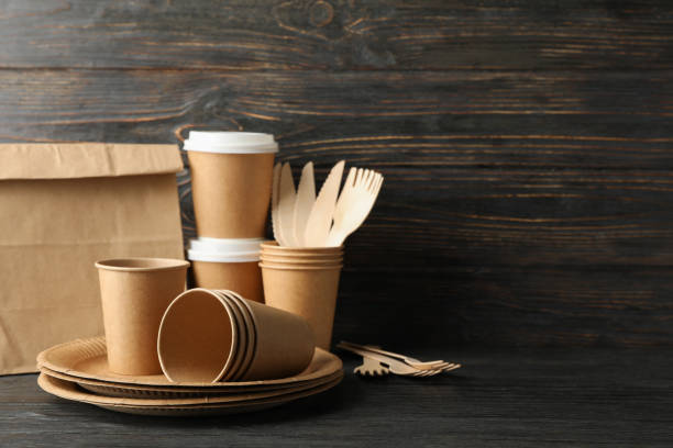 istock Eco - friendly tableware and paper bag on wooden table, copy space 1189933933