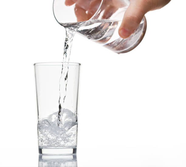 istock pouring sparkling water in a glass on white background, isolated object 1189935623
