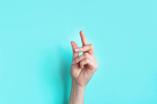 Female snapping hand Female snapping hand on blue background, copy space. Fingers snapping. Snap gesture, minimal concept. click finger stock pictures, royalty-free photos & images