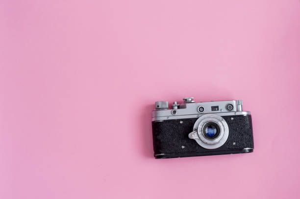 istock Retro photo camera on pink background 1189938242