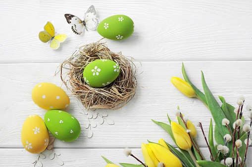Closeup wooden basket with Easter eggs on grass.