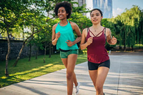 istock Two women jogging in city park 1189942107