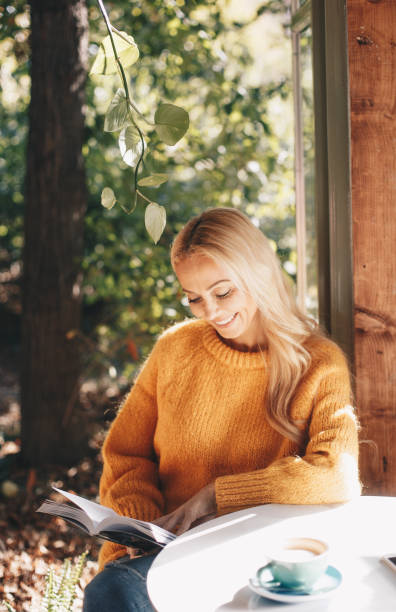 istock Pretty woman enjoin coffee and reading book 1189947442