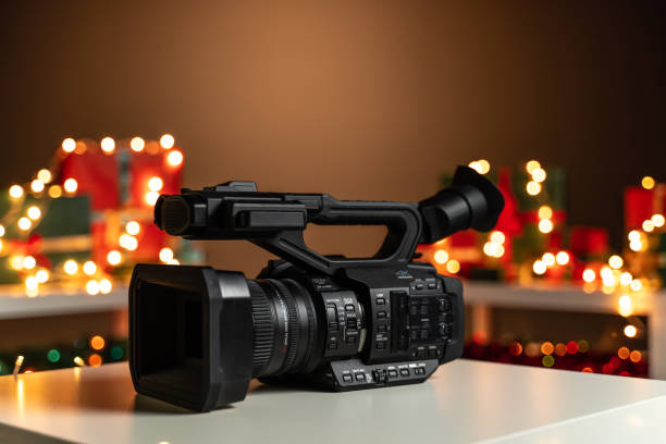 istock Home video camera in front Christmas lights  and presents in background 1189947519