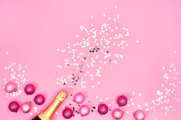 istock Champagne bottle with Christmas decorations on pink background. Top view, copy space 1189947706