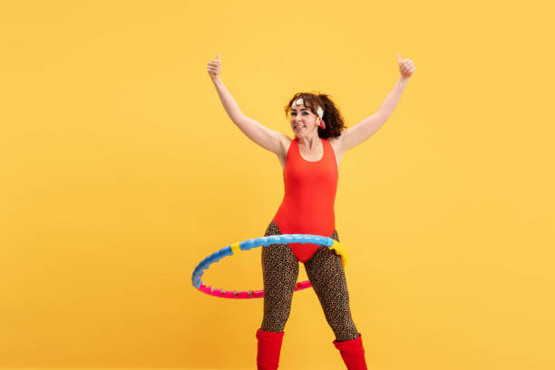 istock Young caucasian plus size female model's training on yellow background 1189947829