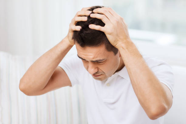 istock unhappy man suffering from head ache at home 1189948932