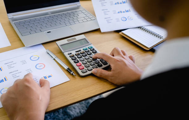 istock Businessman using calculator to calculate financial data report. Monthly account planning work. 1189949214