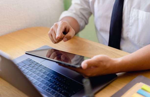 istock Businessman using tablet and laptop on the table in the office. 1189949488