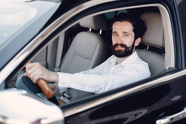 istock Handsome and elegant man in a car salon 1189951820