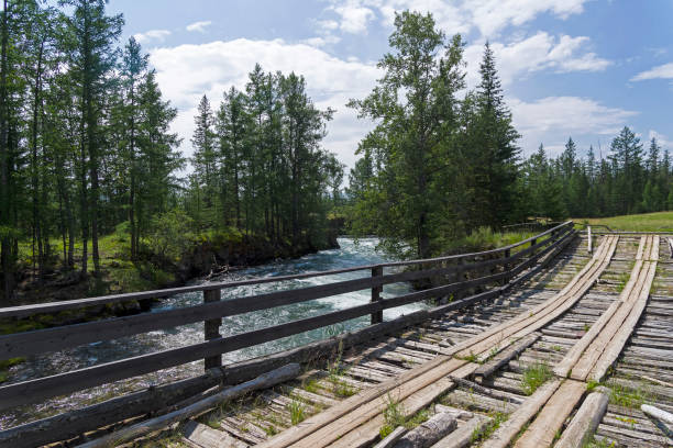 istock Old wooden bridge over the fast river. 1189952147
