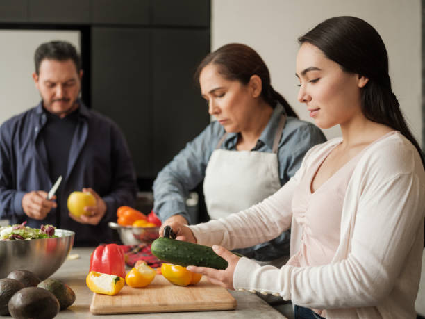 istock Latin family peeling vegetables together 1189952271