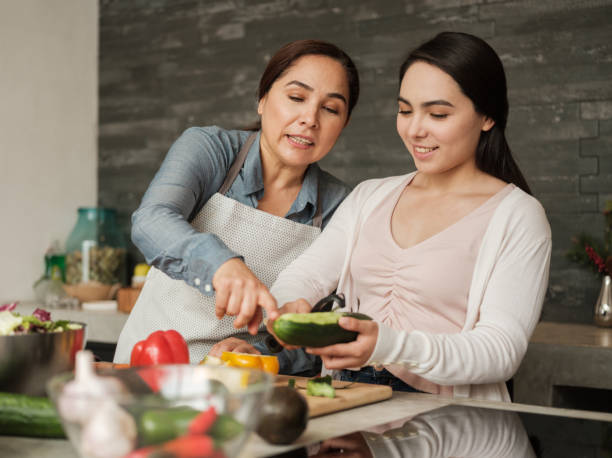 madre e hija latinas preparando comida juntos en casa - cultura mexicana fotos fotografías e imágenes de stock