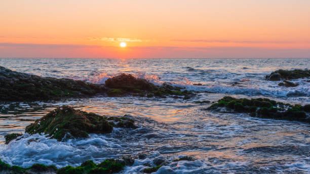 istock Colorful sunrise on a rocky seashore 1189952626