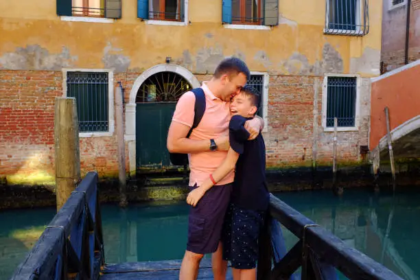 Venice. Italy - October 26, 2019: bonding time of a father and boy - punching, hugging and having fun in Venice while on vacation