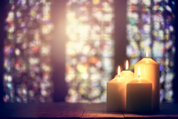 Candles burning in a church background