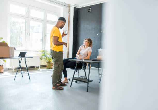 istock Two business colleagues talking to each other in the office 1189960197