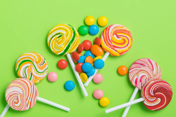 istock many multi-colored caramel candies on a stick lie on a green background 1189960510
