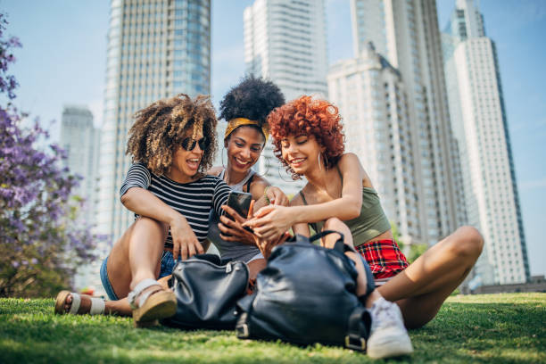 istock Three beautiful ladies sitting on grass in park 1189962270