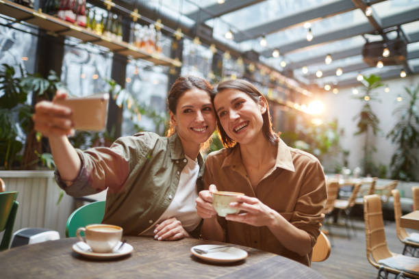 istock Two Women Taking Selfie Photo at Cafe 1189962338