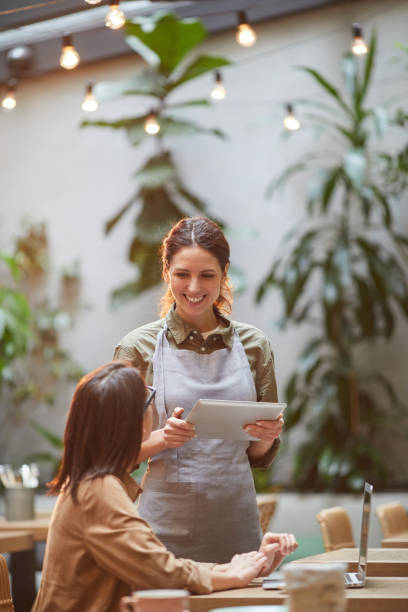 istock Cheerful Waitress Talking to Client at Cafe Terrace 1189962855