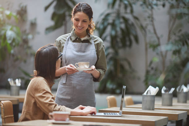 istock Smiling Waitress Bringing Coffee on Outdoor Cafe Terrace 1189962857
