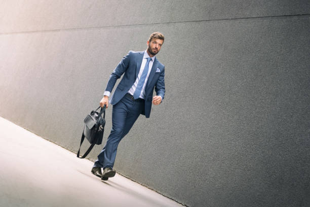 istock Stylish businessman walking outdoors and looking away 1189962982