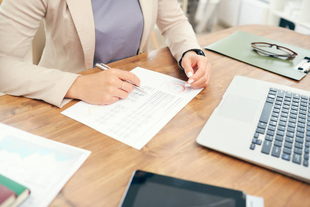 istock Unrecognizable Businesswoman Reading Statistics Report 1189964375