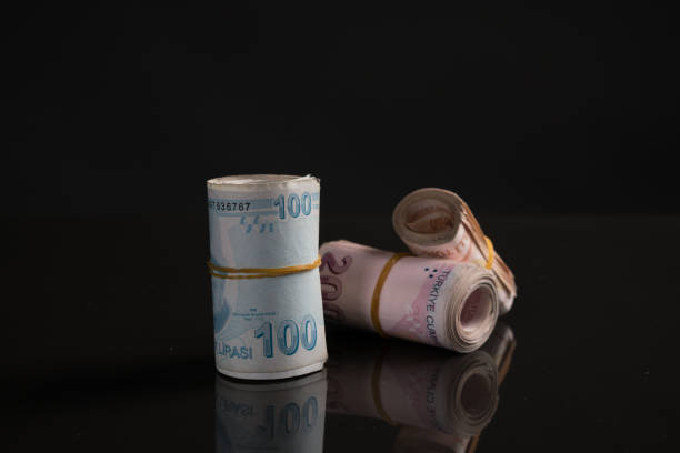 istock Rolled up Turkish lira over black background 1189966090
