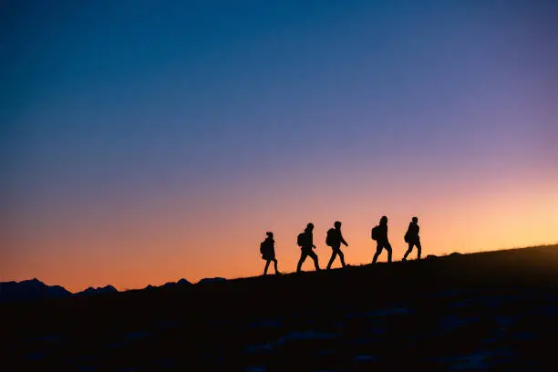 Photo of Group of hikers at sunset mountain