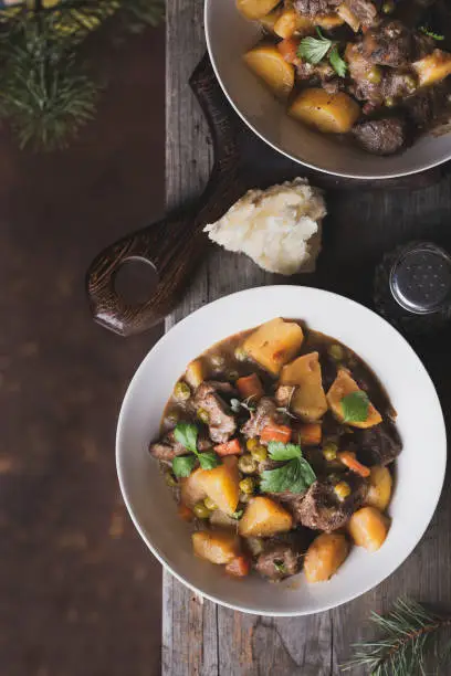 Portion of traditional irish beef and guinness beer stew with carrots, potatoes and green peas