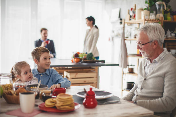 istock Siblings having a conversation with their grandfather during breakfast together 1189972852