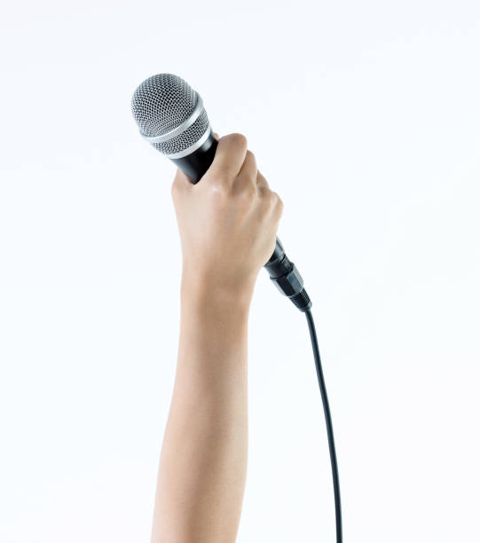 istock Woman hand holding a microphone on white background 1189973295