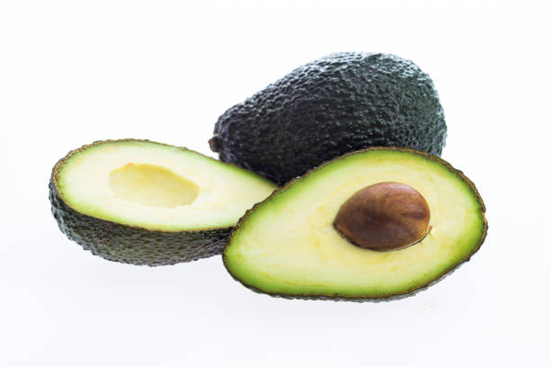 two avocados and one cut in half on white background