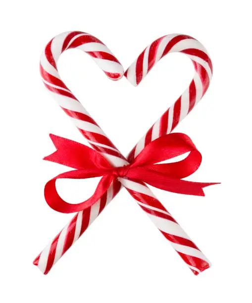 Photo of Two red Candy canes with ribbon Bow heart simbol isolated on white background