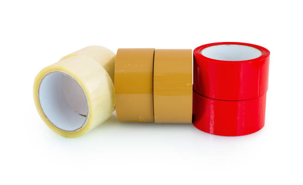 istock Brown, red and transparent (clear) adhesive tape isolated on white background with shadow reflection - clipping path. Reels of sticky tapes.  Parcel packing equipment wallpaper. 1189976125
