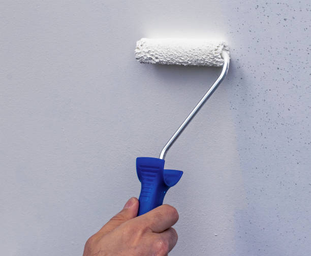 istock Hand painting wall with roll, white paint 1189976190