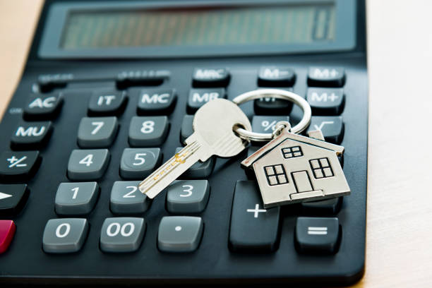 istock Calculator and house key on wooden table 1189977089