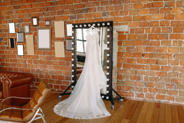 벽돌 벽에 대 한 그레이트 홀에 거울에 매달려 아름 다운 웨딩 드레스 - love hanging indoors studio shot 뉴스 사진 이미지
