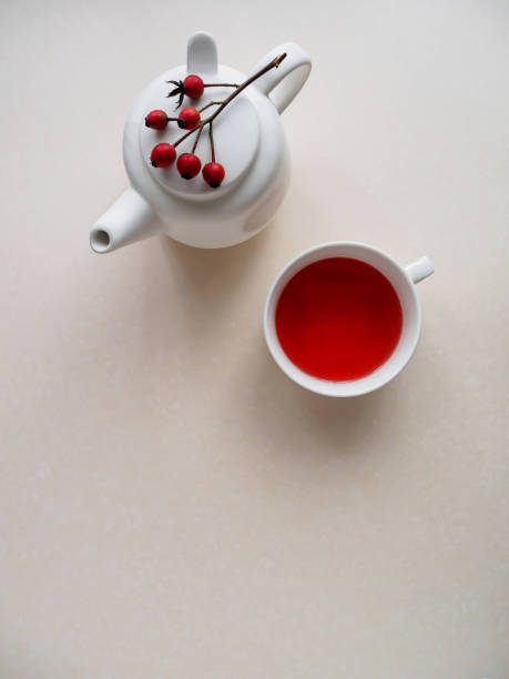 istock Tea with fresh rosehips in a white cup and teapot on a white background 1189978488