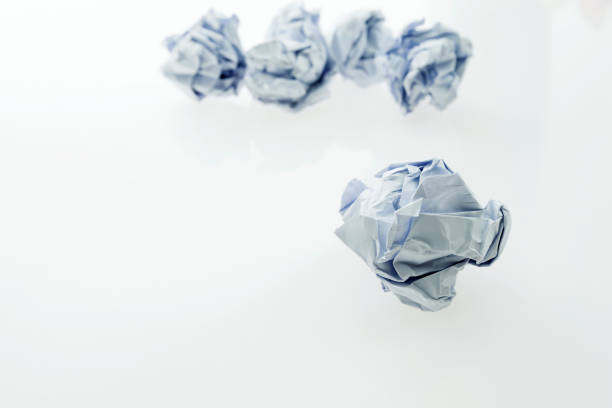 White crumpled paper balls on white background.