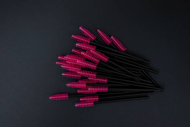 istock Pink mascara brushes on black background 1189979790